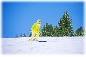 Eine Person mit Skibrille kniet im Schnee und scheint begeistert.