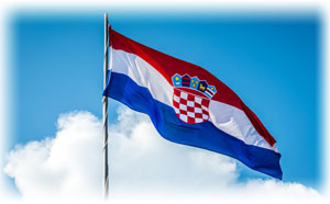 Die Flagge von Kroatien an einem Mast vor blauem Himmel.