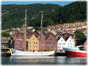 Eine kleine Stadt mit schönen Gibelhäusern und Booten im Wasser davor.
