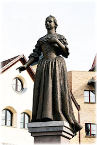Eine Frau auf einem Sockel als Statue.