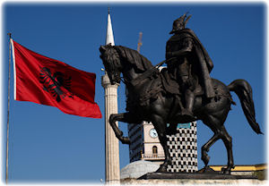 Diese Statue eines Reiters steht in der Hauptstadt Albaniens: Tirana. Das Abbild eines Reiters, zu dessen Seite die rot-schwarze Flagge Albaniens weht.